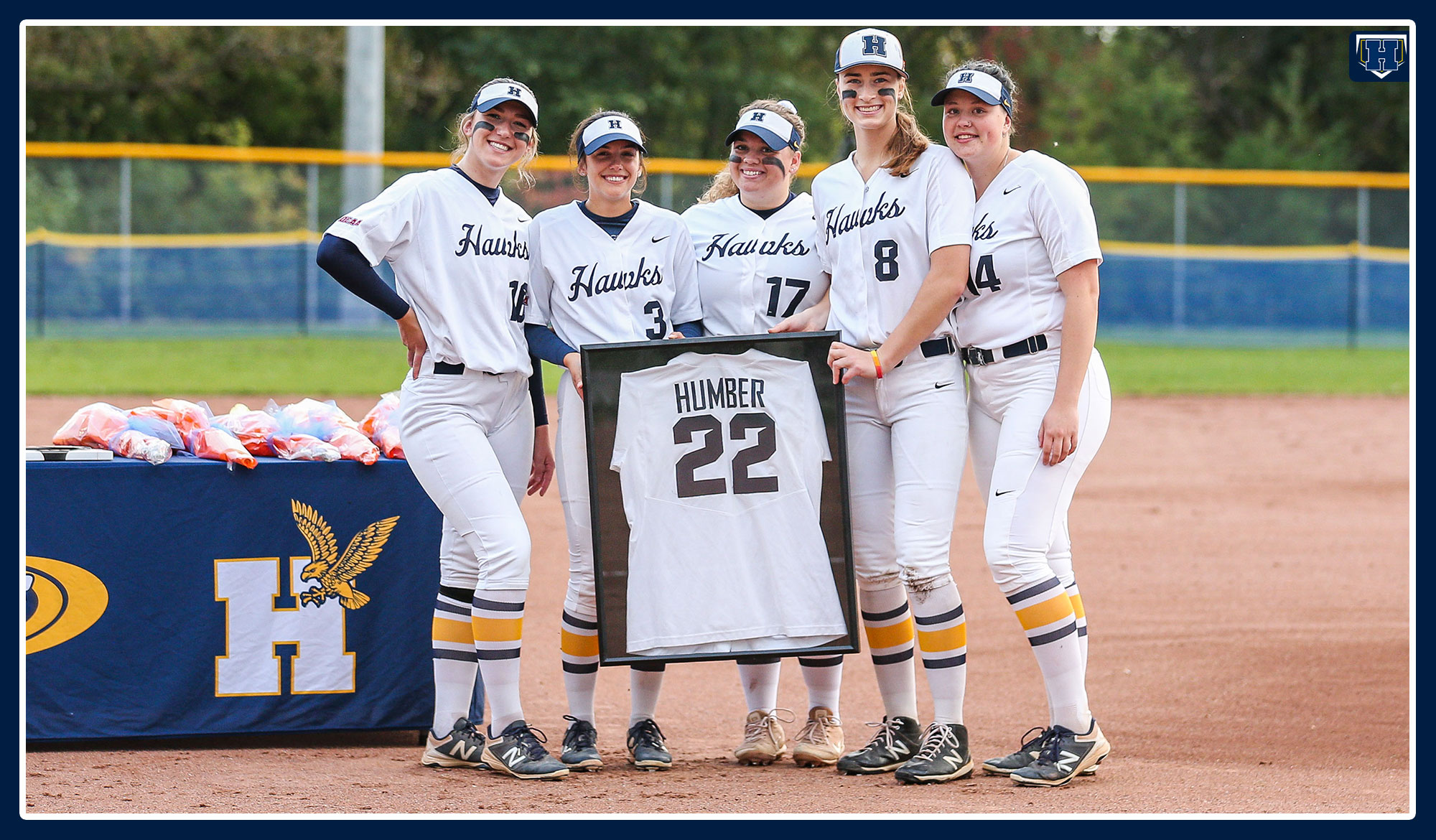 Five softball grads holding the 22 jersey