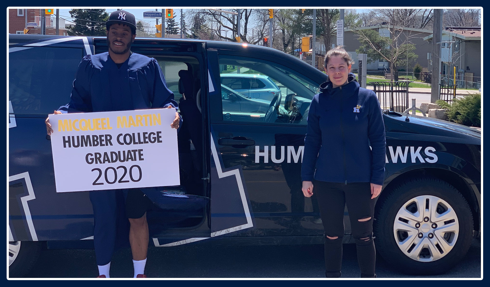 Micqueel and Mallory standing in front of the Humber van, celebrating his graduation